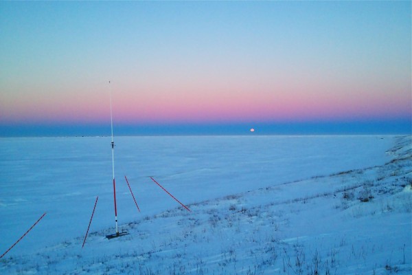 The HF radar transmit tower watches over the frozen Chukchi Sea at Point Lay. We mark 'em with bright orange reflective tape so snowmobilers don't hit them.